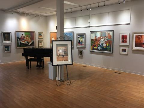 Empty gallery with paintings on the walls and a grand piano