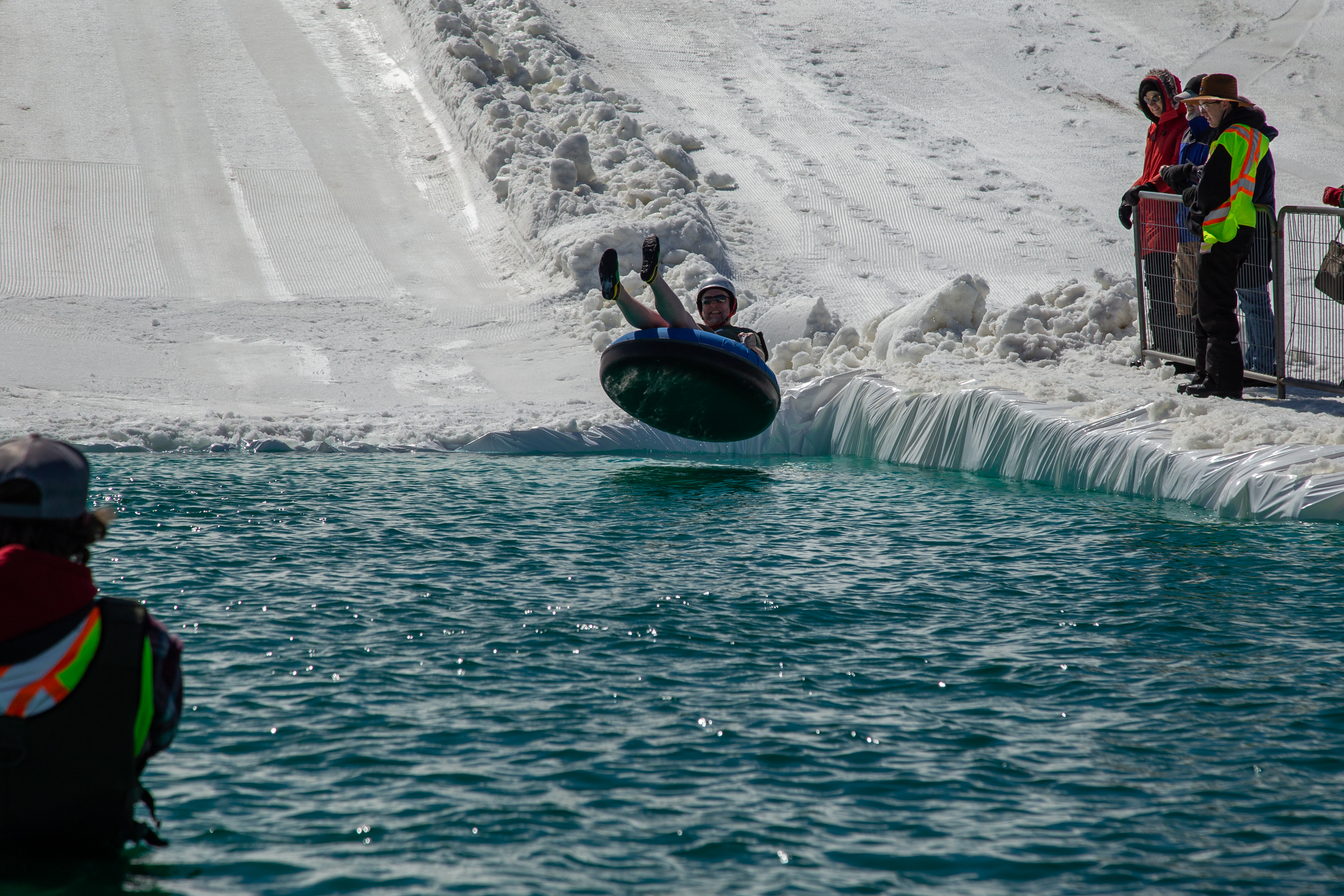 An adult man on an inner tube catches air just before landing in the water at the Puddle Jump event