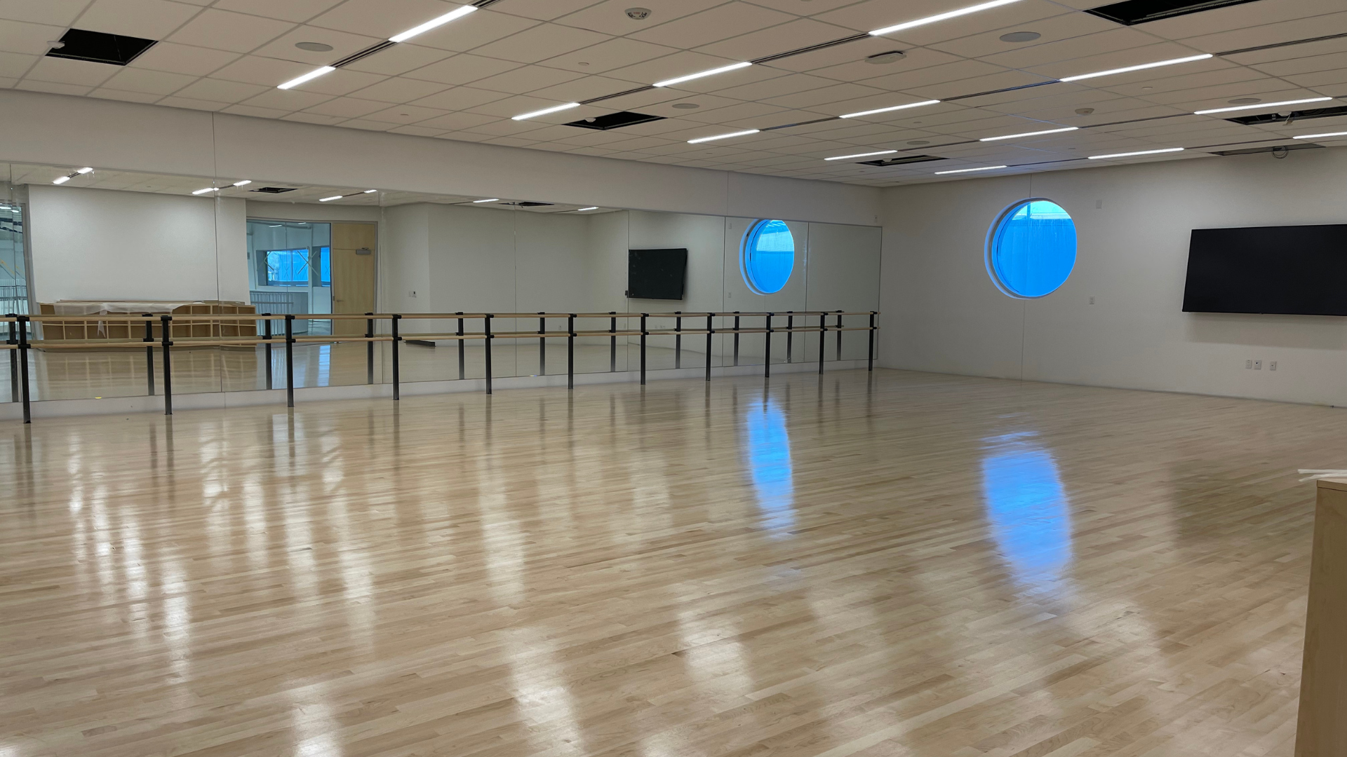 Empty activity room with mirrors and a ballet bar along one wall