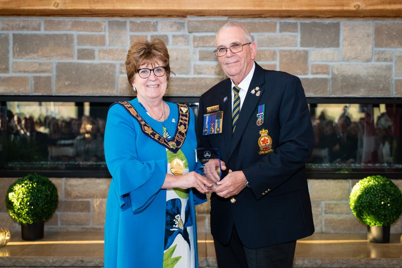 Mayor and man shaking hands in front of a fireplace