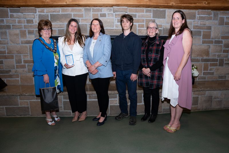 Mayor and group of people in front of a brick wall