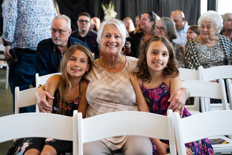 woman and two children sitting in white chairs