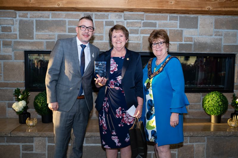 councillor, recipient and mayor standing in front of a fireplace