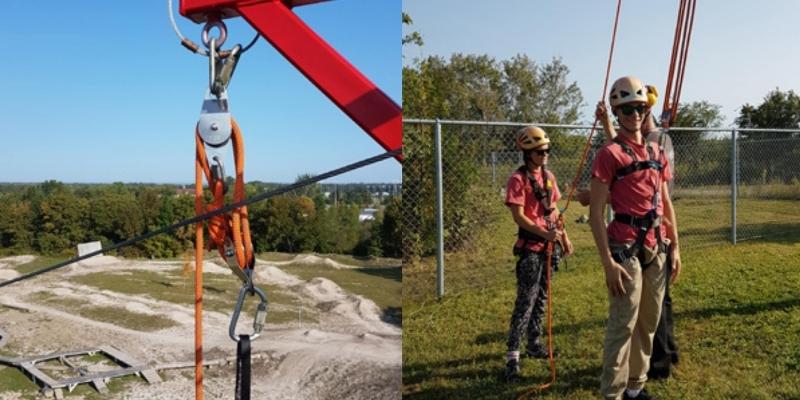 Accessible arm for lifting at the Challenge course at the ROC and one person strapped into the arm with support guide person