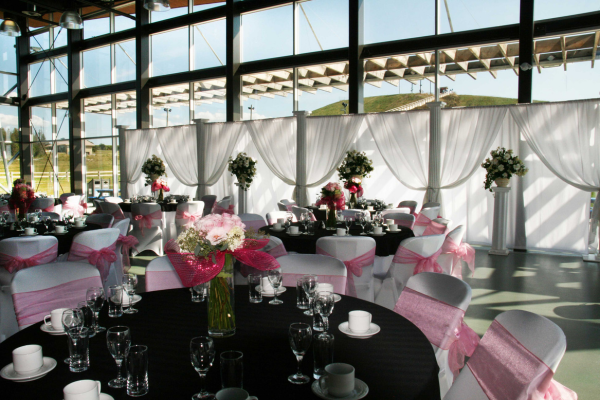 Decorated facility with a table with place settings and a white backdrop
