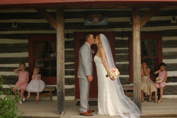 Bride and groom kissing in front of historic building