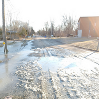 Damaged dirt road in the country with puddles