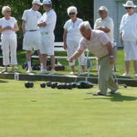 Group of older adults playing lawn bowling