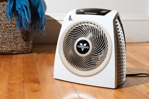 A space heater on wood floor with basket in the background
