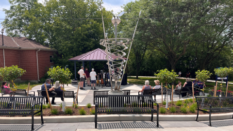 Metal structure in the middle of a park with people around