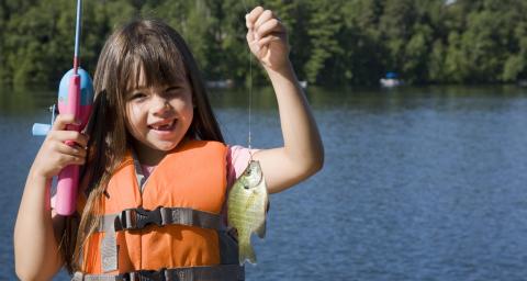 Fishing in Georgina girl holding her fishing catch on Lake Simcoe in Georgina