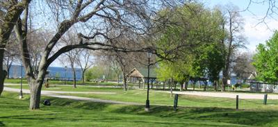 Park with pathway and trees and lake in background