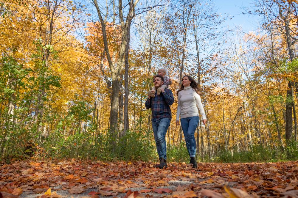 parents and child walking in fall foliage