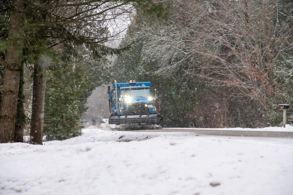 Decorative - Snow plow on winter road with snowy trees