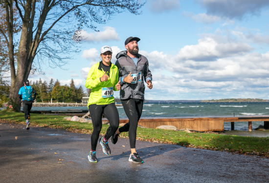 two people running a race along the lake