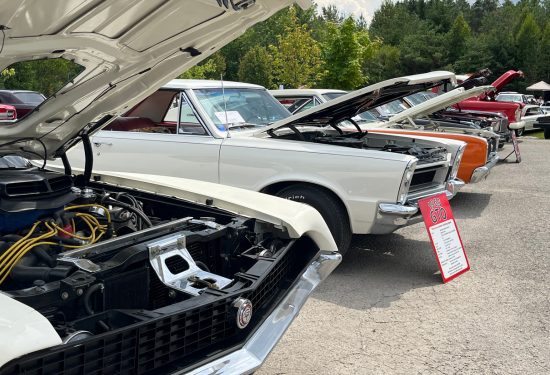 classic cars with the hoods up lined up in a line