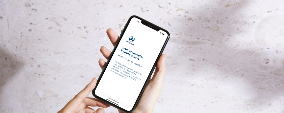 hand holding cell phone with a survey page on the phone