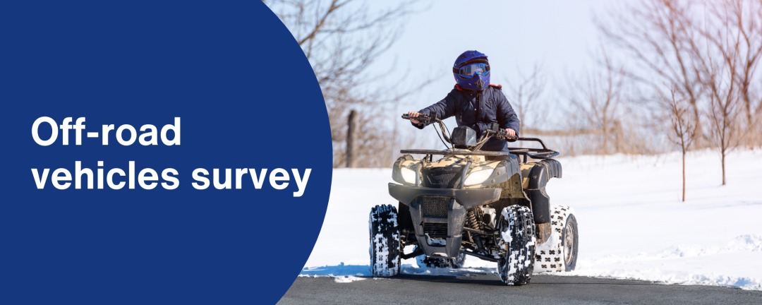 person on an off-road vehicle on road with snowy field in background