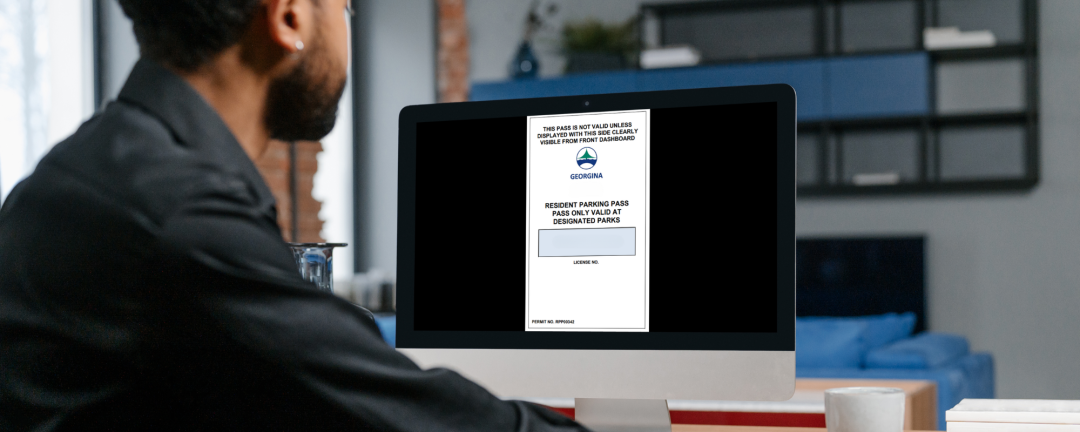 person on computer with parking pass application on screen